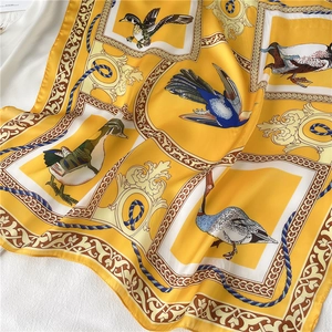 Detail van zijden sjaal met gele vogelpatronen en barokke gouden krulmotieven