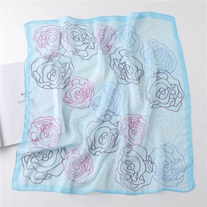 Detailed close-up of light blue floral chiffon silk square scarf with rose patterns