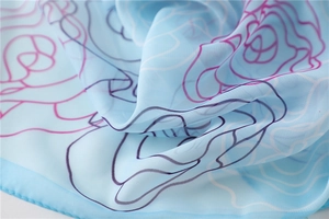 Close-up of light blue floral chiffon scarf showing soft texture and rose line patterns