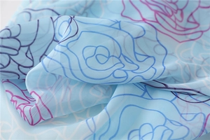 Detail of light blue floral chiffon scarf with rose patterns and soft translucent texture
