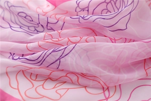 Detail of soft pink chiffon scarf with elegant rose print texture and semi-transparent fabric