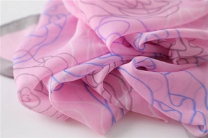Detailed view of pink floral chiffon scarf with elegant silk-like texture and soft folds