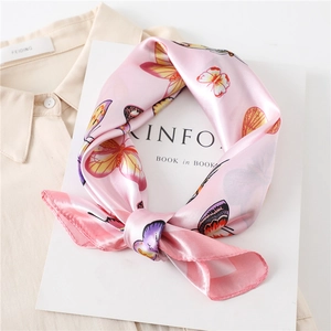 Pink silk square scarf with colorful butterfly print on Kinfolk magazine and beige shirt