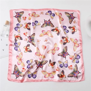 Detailed view of pink silk scarf with colorful butterfly patterns on white background