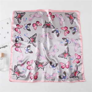 Detail of silk square scarf showing butterfly print and pink satin edge stitching