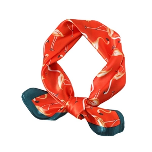 Elegant silk scarf with flamingo print and green border in a stylish knotted display