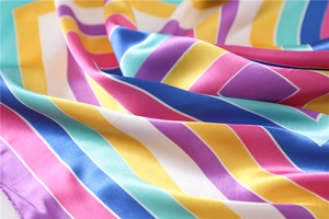Detail of colorful striped silk scarf showing glossy satin texture and vibrant fabric folds