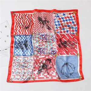 Gros plan d'un foulard en soie avec motifs pied-de-poule, fleurs et bords rouges