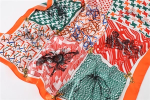 Détail d'un foulard en soie coloré avec motifs pied-de-poule et fleurs en gros plan