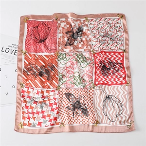Détail d'un foulard en soie à motifs floraux et pied-de-poule avec une carte LOVE décorative