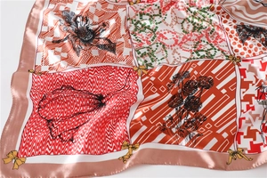 Détail macro d'un foulard en satin brillant avec motifs imprimés et bords roulés