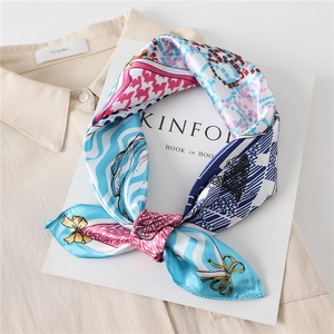 Détail d'un foulard carré en satin avec motif pied-de-poule coloré et nœuds
