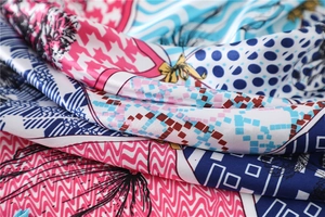 Détail macro d'un foulard en soie avec motifs pied-de-poule et géométriques colorés