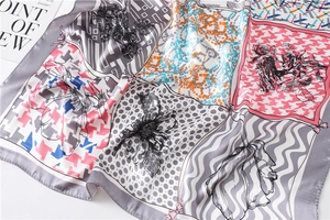 Détail d'un foulard en soie imprimé avec pied-de-poule, motifs floraux et texture satinée
