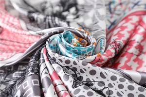 Vue macro d'un foulard en soie aux motifs pied-de-poule, floraux et géométriques élégants