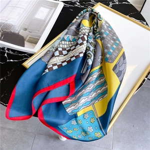 Detailed close-up of premium silk-like scarf with diverse geometric patterns and red edges