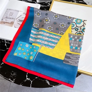 Detail of artistic silk scarf with bold geometric floral patterns on marble table
