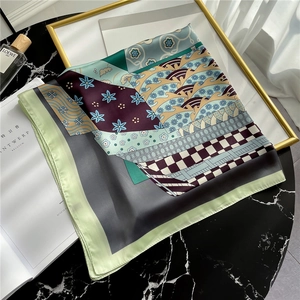 Close-up of premium floral and geometric print silk scarf on marble surface