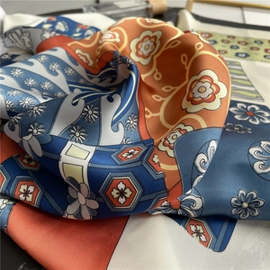 Detail of elegant silk scarf with vintage floral and geometric patterns in soft folds