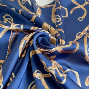 Detailaufnahme des marineblauen Seidenschals mit goldenen Ketten und Zaumzeugmustern