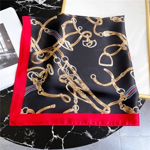 Detail eines 70cm Seiden-Square-Schals mit goldener Kette und Gebissmotiven auf Marmor