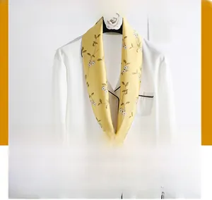 Detail of light yellow floral silk scarf paired with a white silk shirt for women