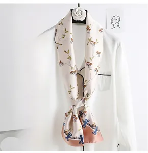 Detail of floral skinny scarf tied on white shirt showing retro patterns and fine texture