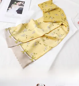Detail of yellow floral silk scarf draped over a white top for French style