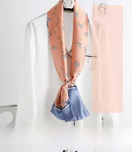 Close-up of narrow floral silk scarf styled on a white shirt with satin floral texture
