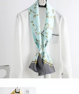 Detail view of light blue floral skinny scarf styled on a white shirt collar