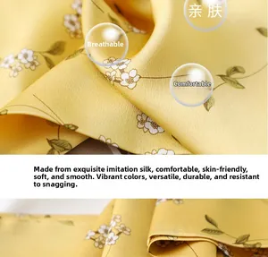 Close-up of yellow silk scarf fabric with small white floral print and soft texture