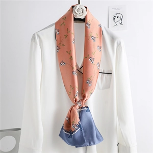 Floral skinny silk scarf in peach pink and navy blue styled on a white shirt