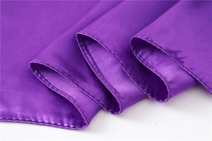 Close-up of dark purple silk scarf featuring a high-gloss finish and fine machine stitching