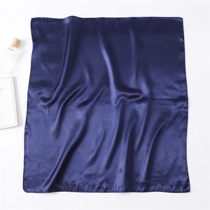 Detailed view of dark blue silk scarf showing soft satin texture and elegant glossy finish