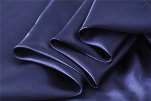 Detailed macro view showing the smooth texture and gloss of dark purple silk scarf fabric
