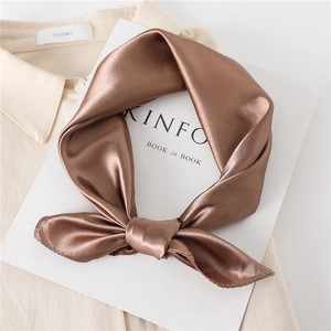 Brown satin square silk scarf tied in a bow on a white shirt with Kinfolk magazine