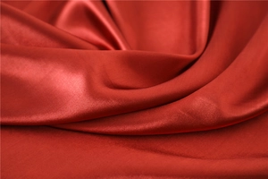 Close-up of red silk satin scarf showing smooth texture and luxurious glossy finish