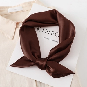 Detail of coffee brown satin silk scarf with premium gloss on a white magazine board