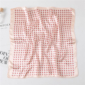Detail of checkered satin scarf next to a perfume bottle in a minimalist elegant setting