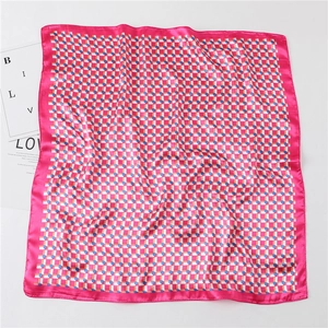 Flat lay detail of plaid faux silk square scarf with vibrant pink borders on white background