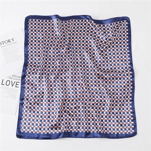 Flat lay of silk scarf featuring blue geometric plaid and bright orange dot patterns