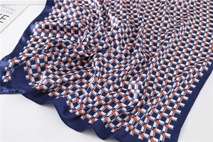 Detail of plaid silk satin scarf showing navy blue and orange geometric patterns