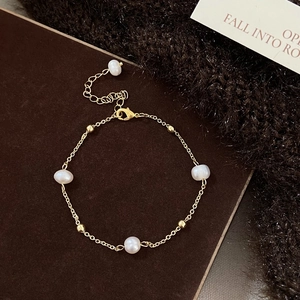 Detail of gold pearl bracelet featuring a lobster clasp and adjustable extension chain