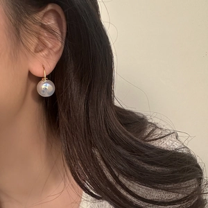 French vintage mermaid pearl drop earrings in gold shown on a model profile view