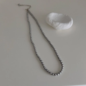 Close-up of dark grey pearl beaded necklace with metallic lobster clasp and extender