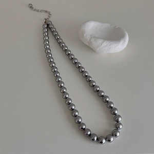 Close-up of elegant grey pearl necklace with metallic luster and silver clasp detail