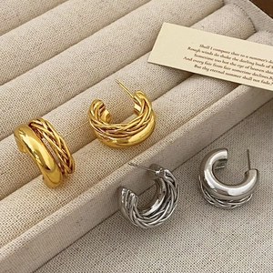 Vue détaillée des boucles d'oreilles créoles doubles dorées et argentées à textures tissées