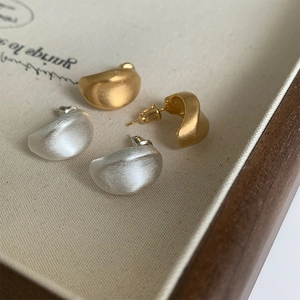 Orecchini minimalisti in metallo spazzolato oro e argento su vassoio in legno