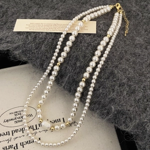 Détail d'un collier de perles d'eau douce à double rang avec pendentif baroque et fermoir doré