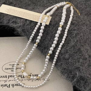 Détail du collier de perles d'eau douce double rang avec perle baroque et fermoir doré